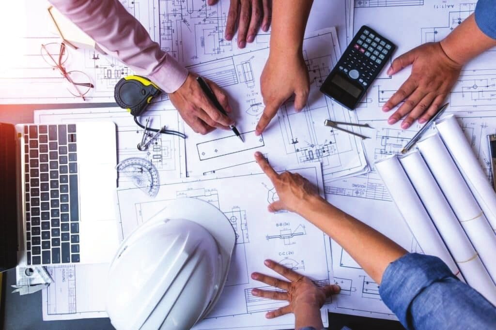 مهندسون يراجعون المخططات على طاولة العمل